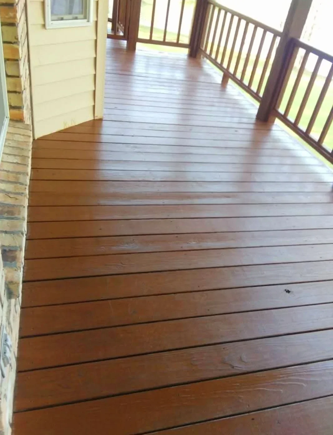 Newly stained wood deck with rich brown finish and dark wood railings