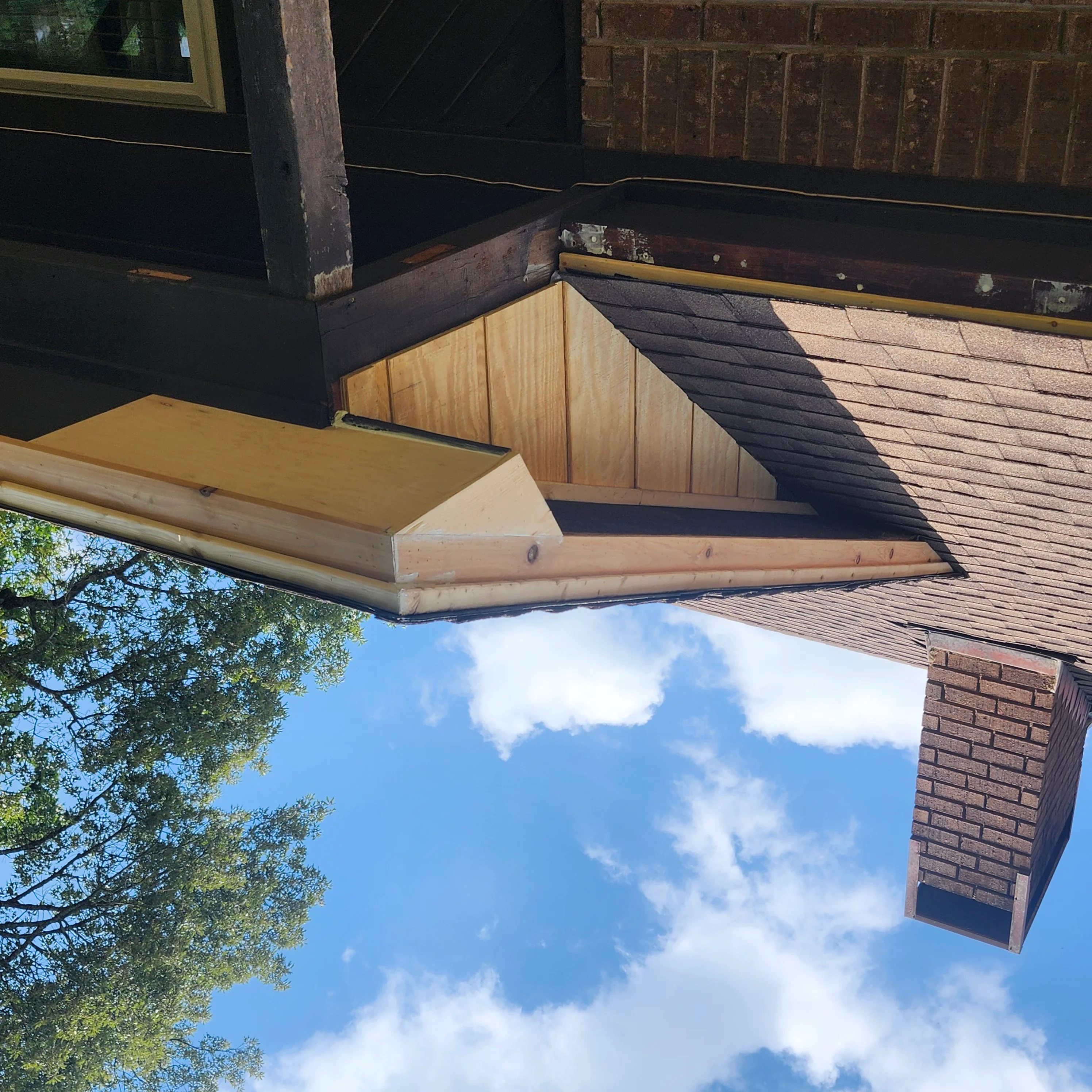 Newly painted wooden soffit and fascia boards with fresh coating along roofline