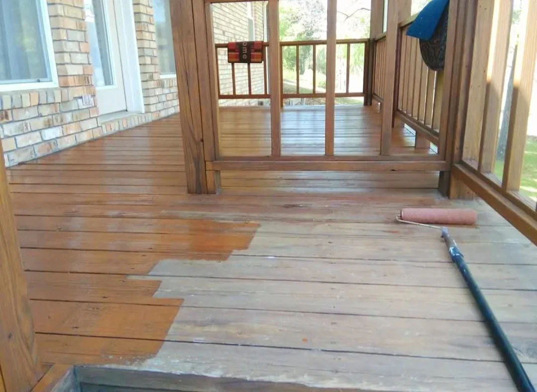 Wooden deck with partial staining application, showing refinished and weathered wood sections