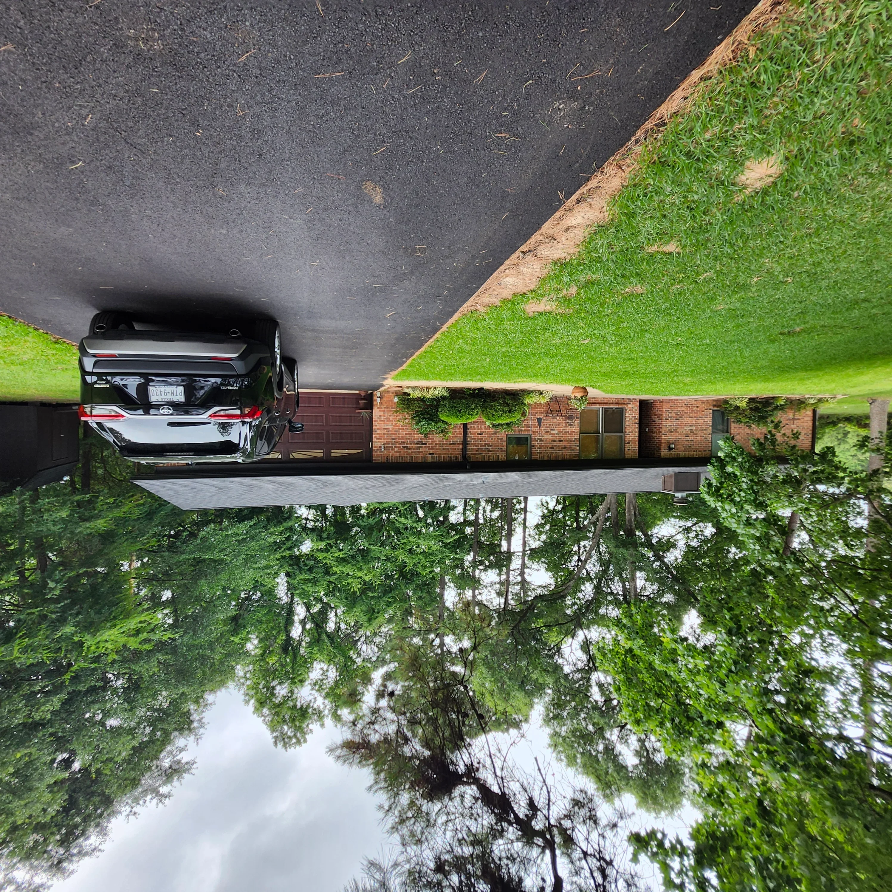 Freshly sealed asphalt driveway with dark protective coating and clean edges