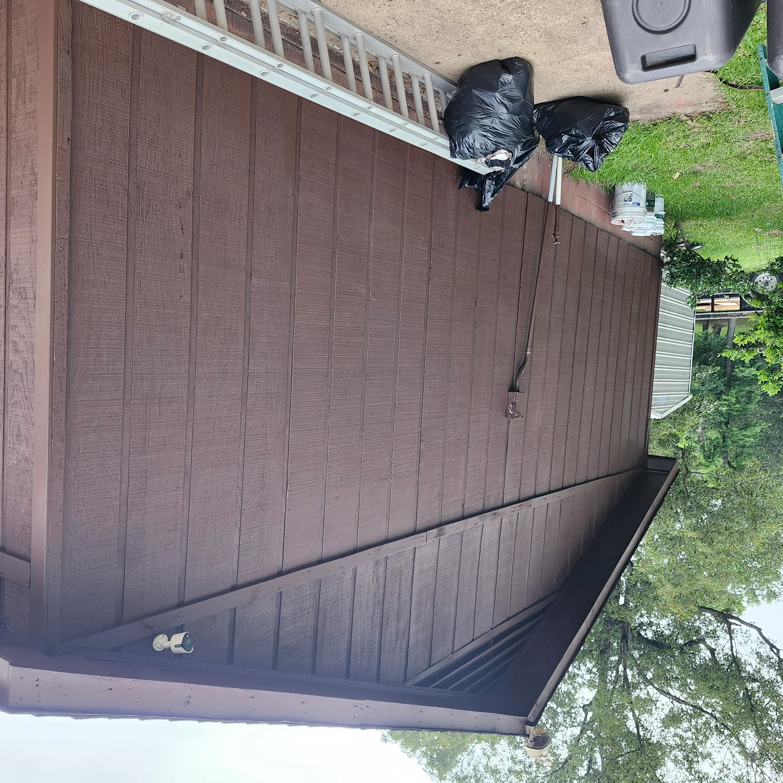 Brown painted garage door with vertical panel design and black rubber seal