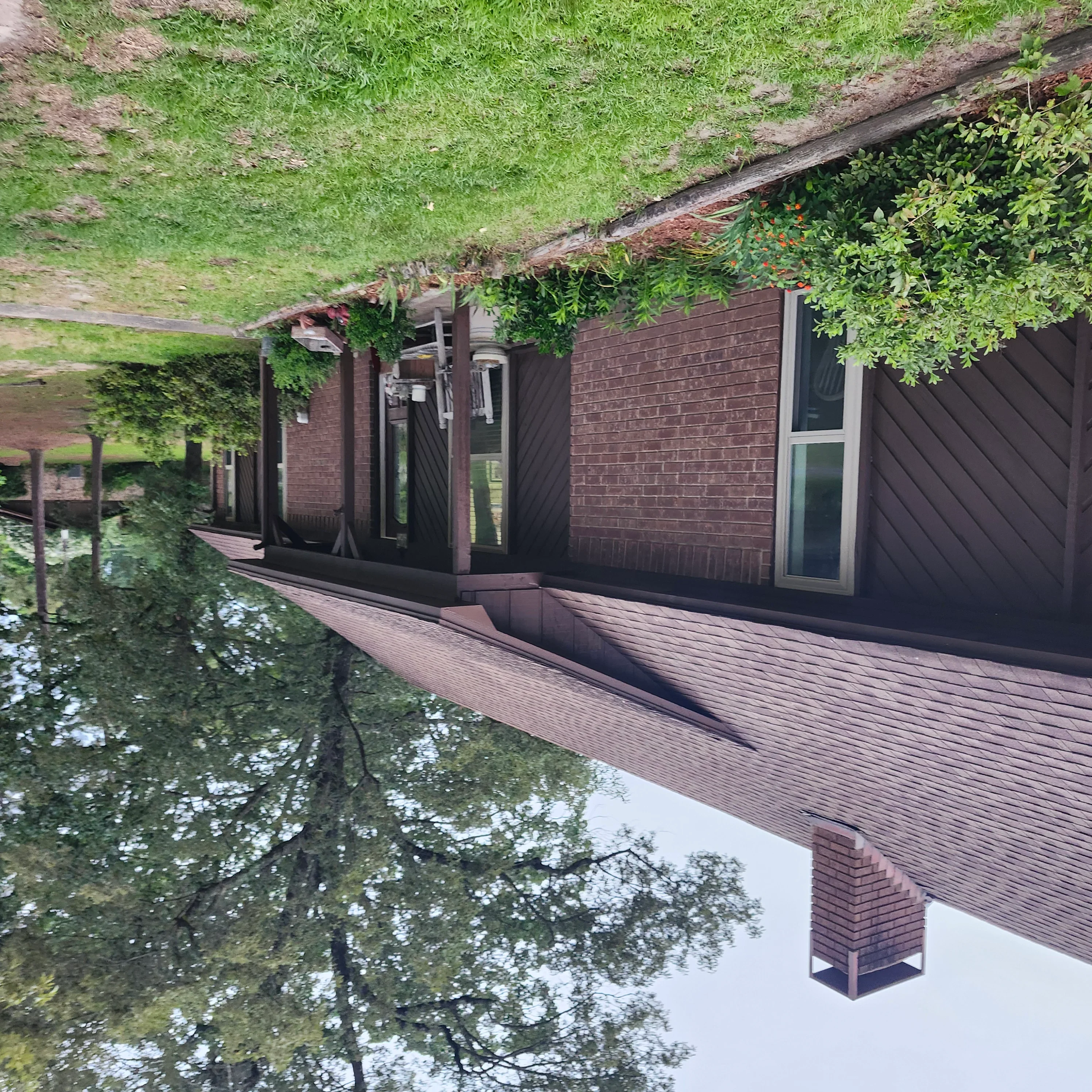 Dark-stained composite deck with painted trim, brick siding, and pergola structure
