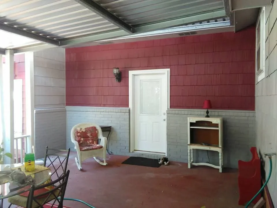 Two-tone painted garage interior with red upper walls, gray lower walls, white door, and metal ceiling