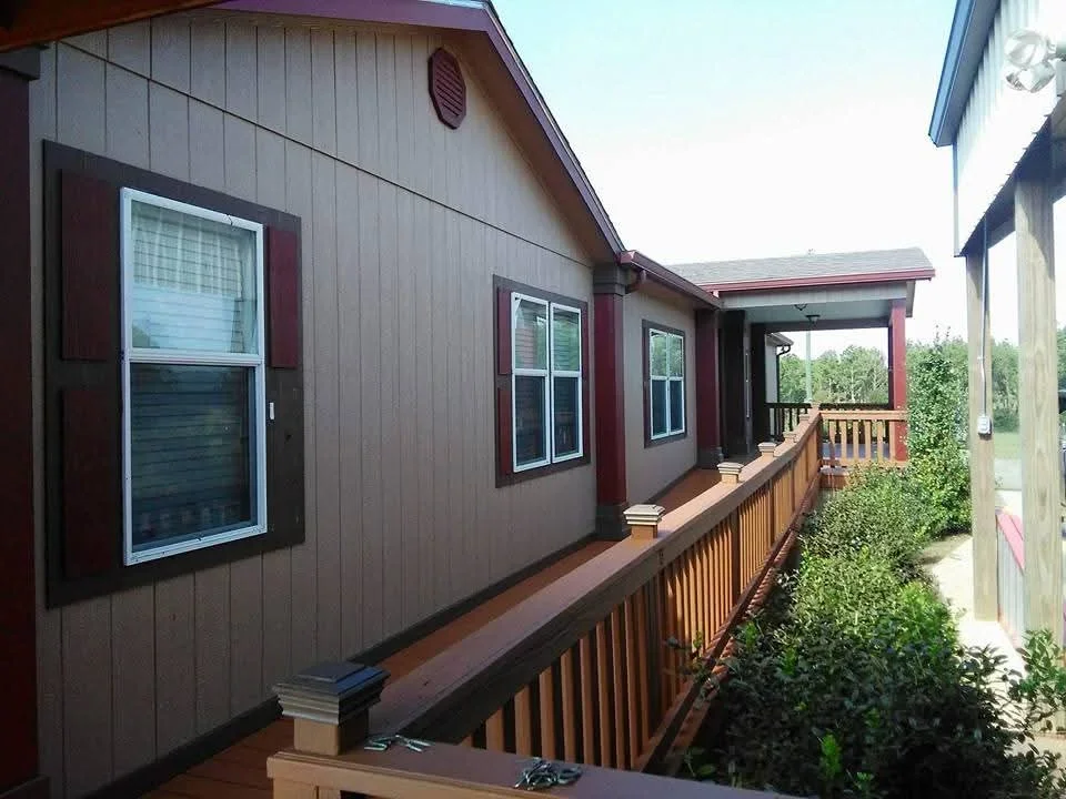 Taupe vertical siding with burgundy trim, painted windows and doors, stained wood deck railings