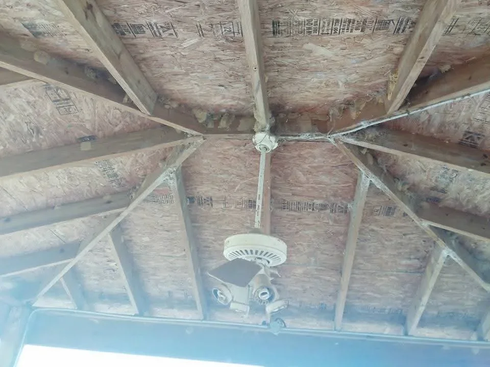 Exposed ceiling framing with OSB sheathing, lumber joists, and mounted smoke detector