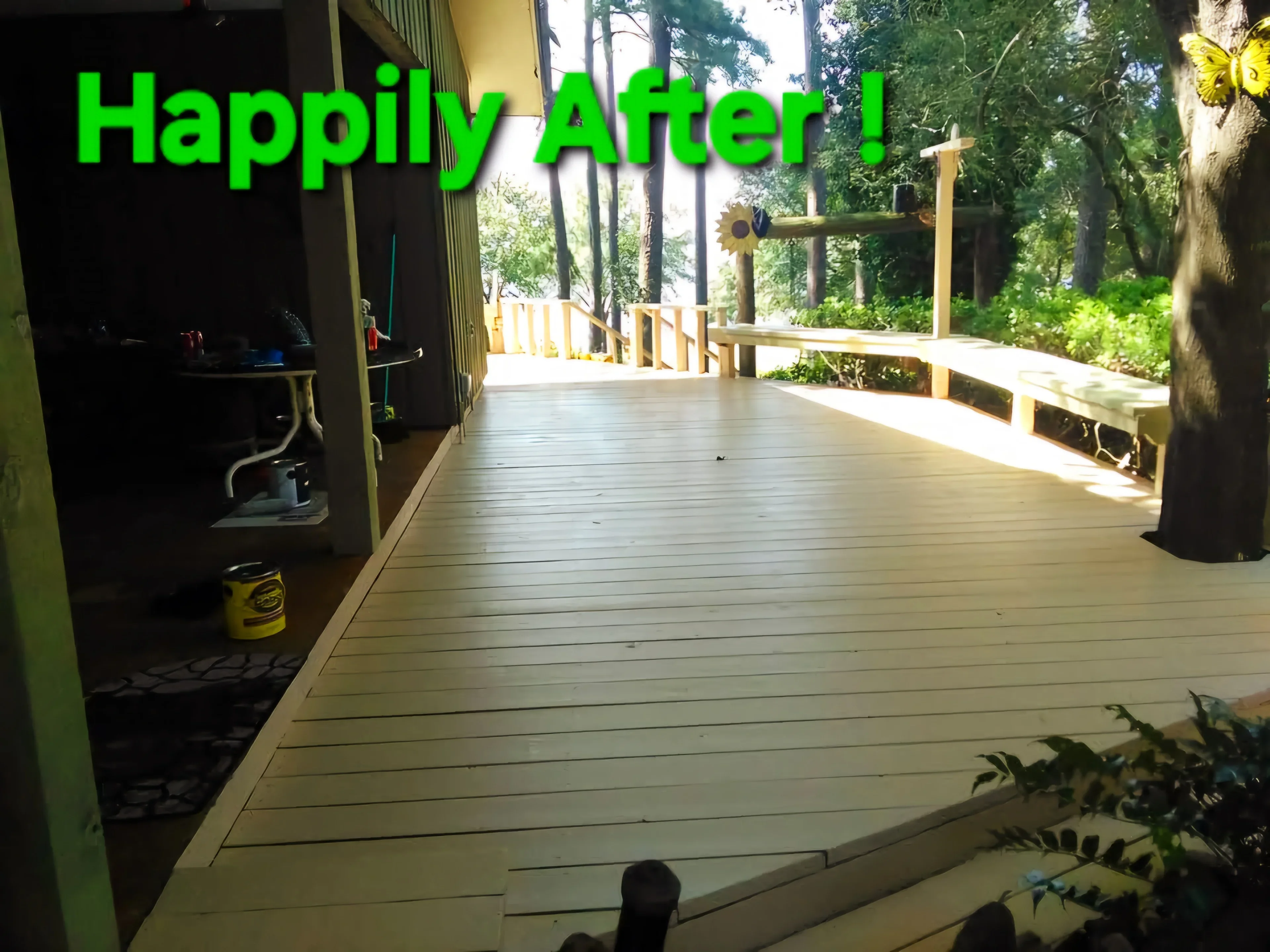 Freshly painted composite deck with wood railings and trim overlooking wooded landscape