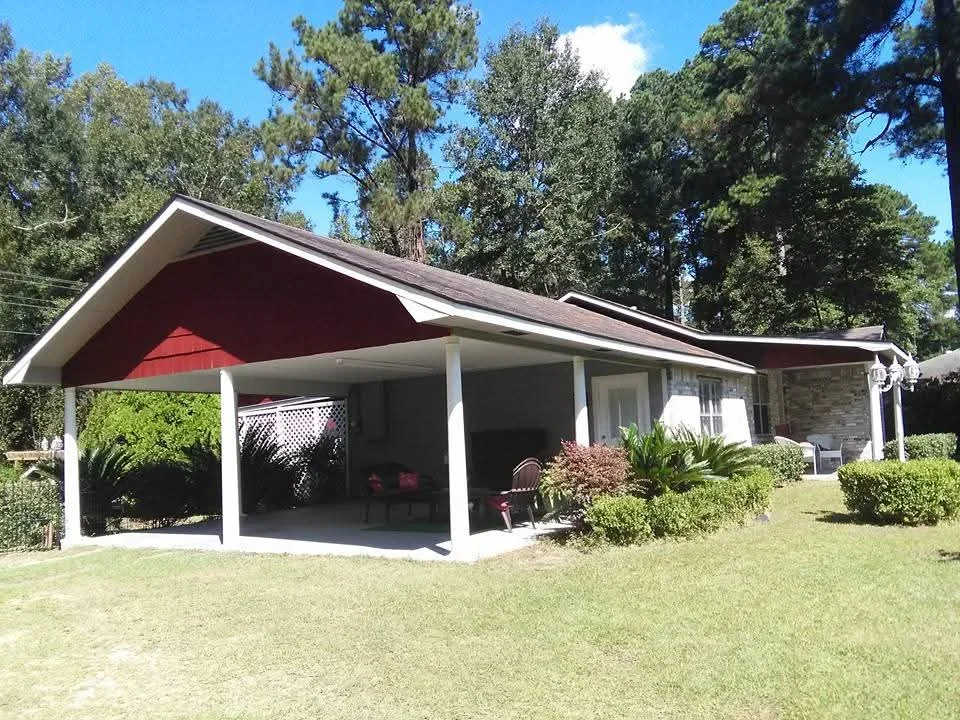 White-trimmed ranch home with burgundy roof and carport, freshly painted exterior